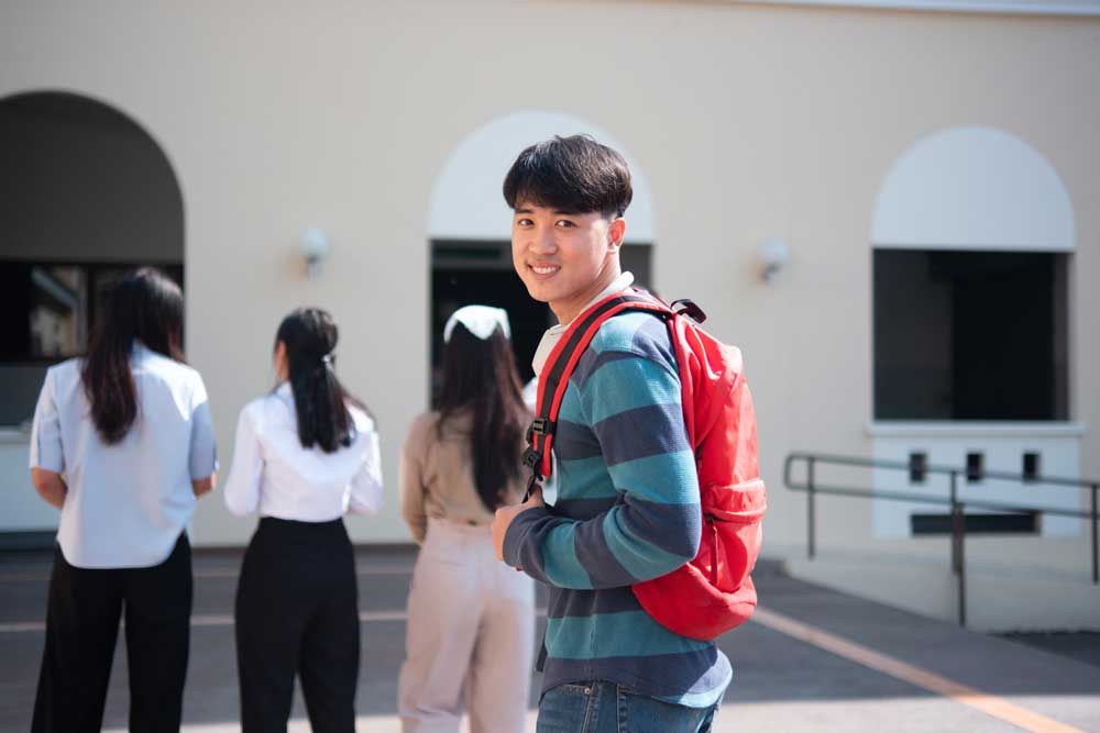 Smiling student outside of a university building